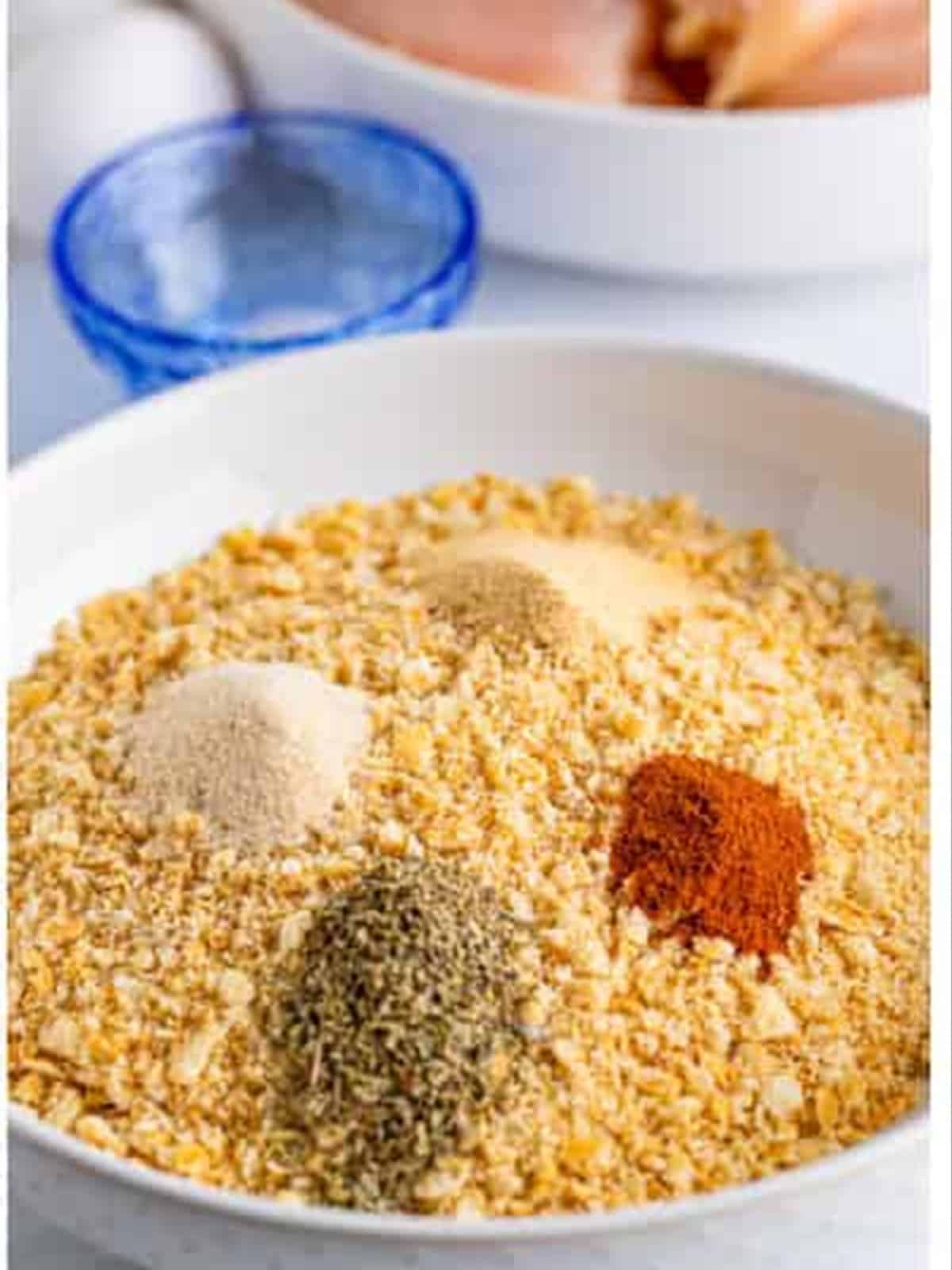 Adding spices to crushed Ritz crackers for Ritz cracker chicken.