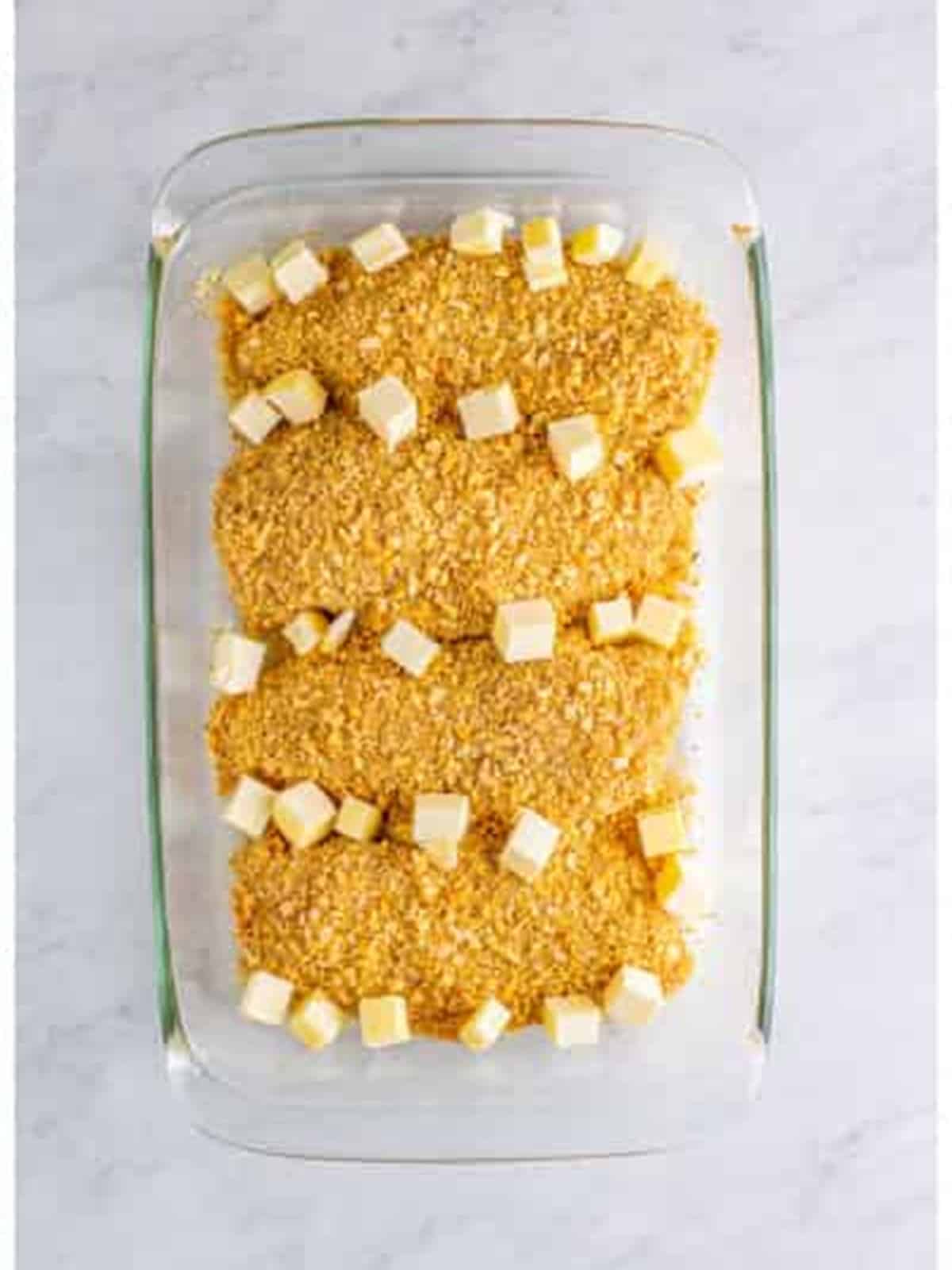 Dotting the Ritz cracker chicken with butter.