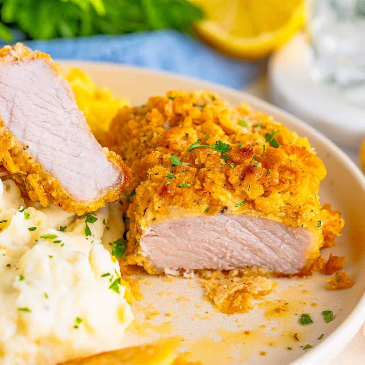 Overhead view of crispy Ritz cracker baked pork chops in a baking dish garnished with parsley.
