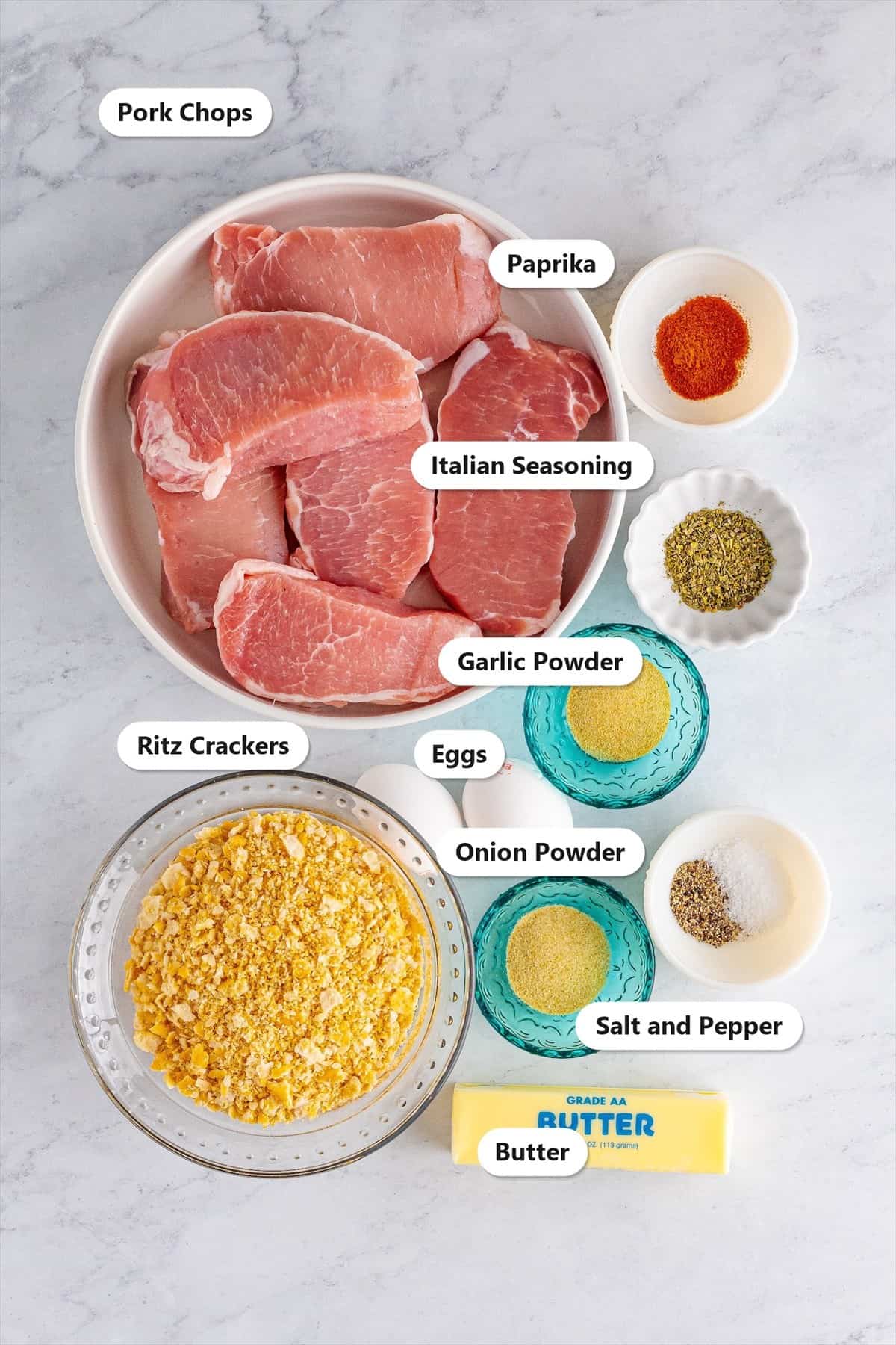 Labeled ingredients for Ritz cracker pork chops including pork chops, crushed Ritz crackers, eggs, butter, paprika, Italian seasoning, garlic powder, onion powder, and salt and pepper.