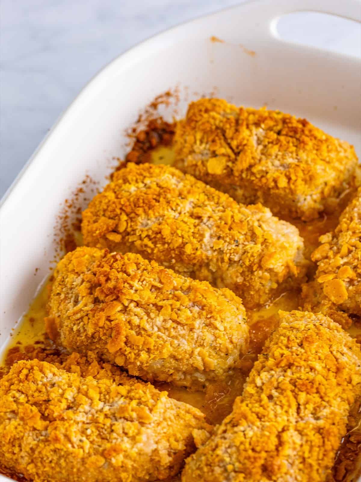 Golden baked Ritz cracker pork chops in a baking dish, crispy and crusty on top.