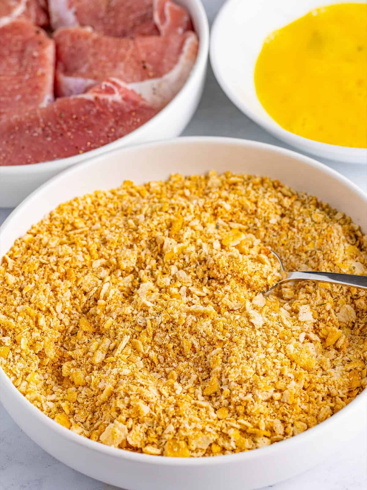 Crushed Ritz crackers mixed with garlic powder, onion powder, Italian seasoning, and paprika in a shallow bowl.