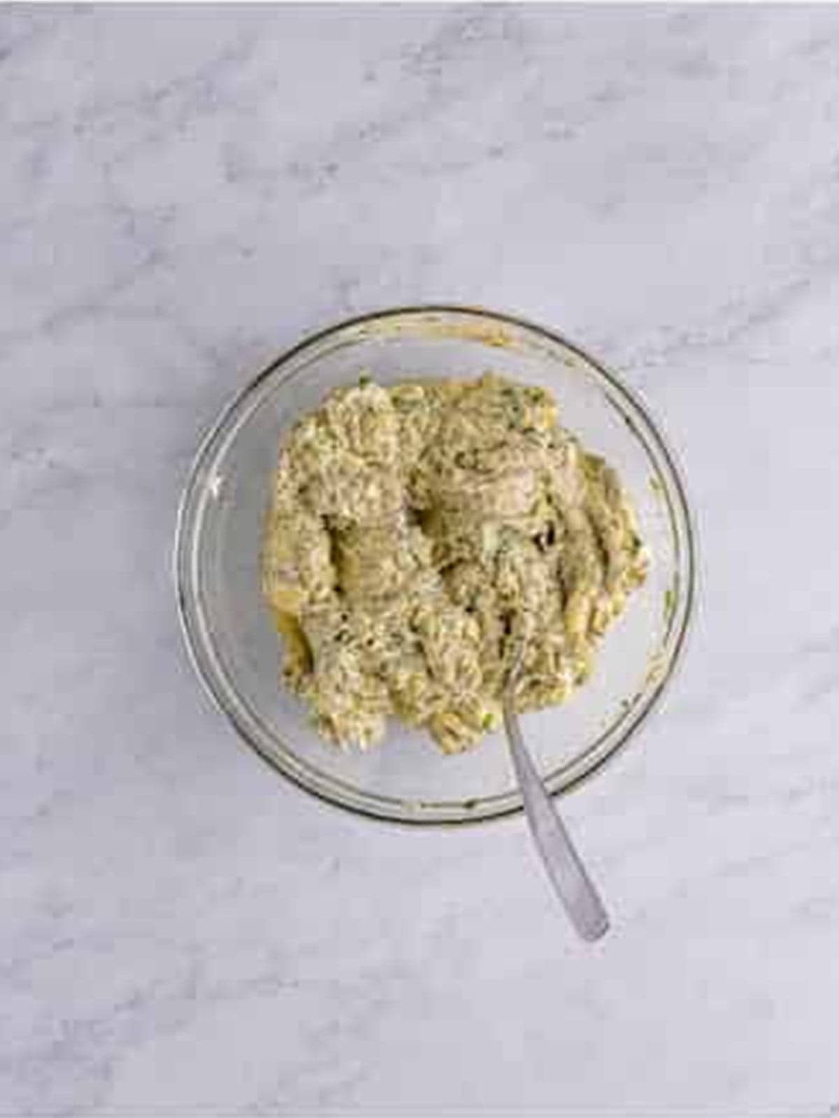 Compound butter with garlic and fresh herbs mixed in a bowl for roast turkey.