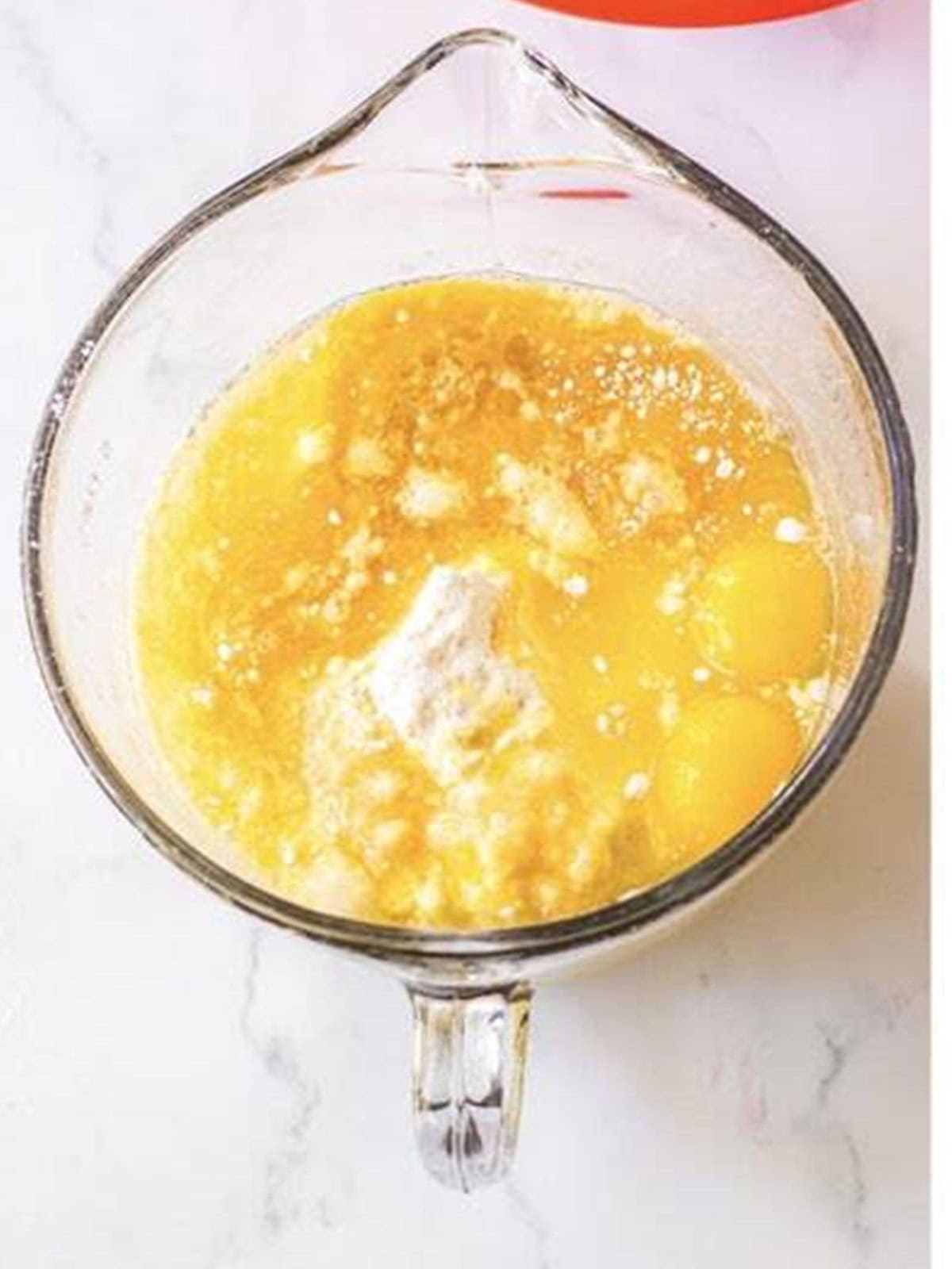 Cake mix, pudding, eggs, water, oil, and rum being mixed in a bowl.