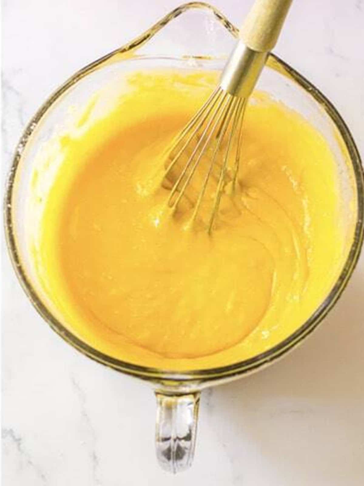 Smooth rum cake batter mixed in a glass bowl.