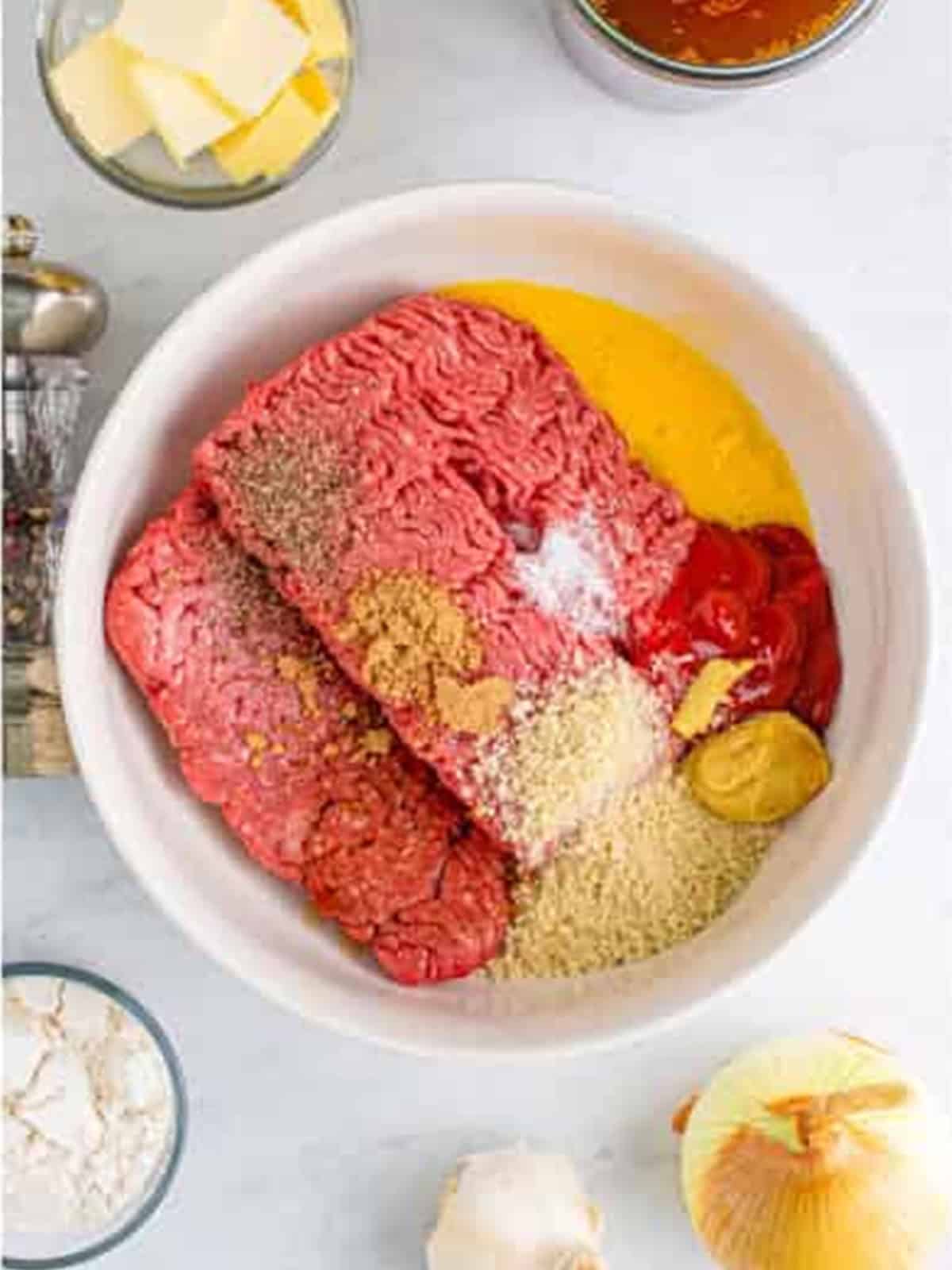 Ground beef, egg, breadcrumbs, and seasonings combined in a bowl for salisbury steak.
