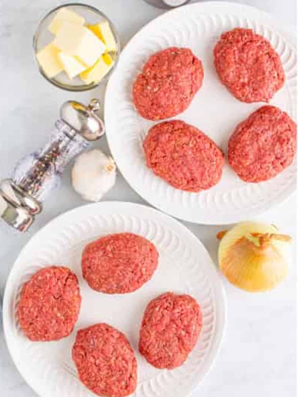 Ground beef formed into oval salisbury steak patties on a plate.