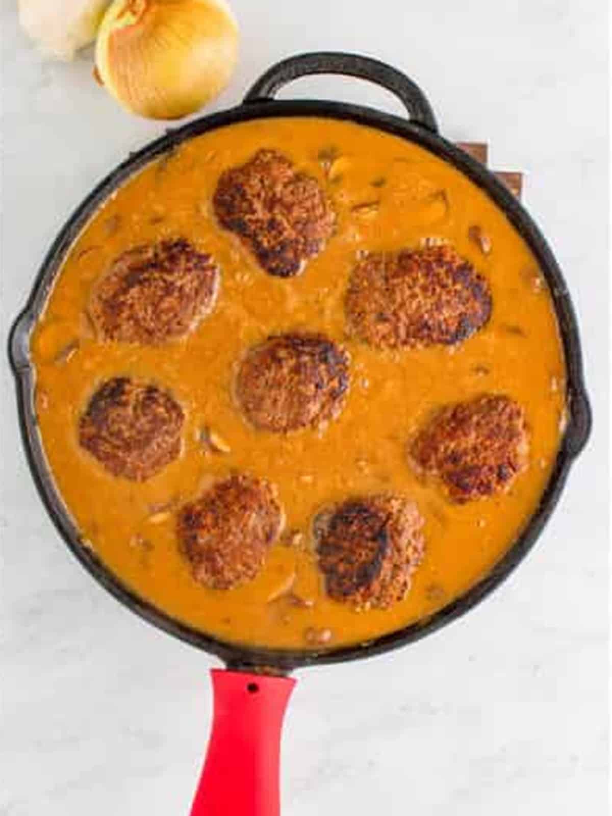 Salisbury steaks simmering in rich brown mushroom gravy.