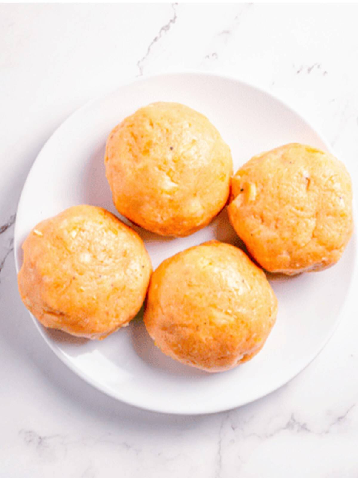 Forming the salmon mixture into equal patty balls on a white plate.