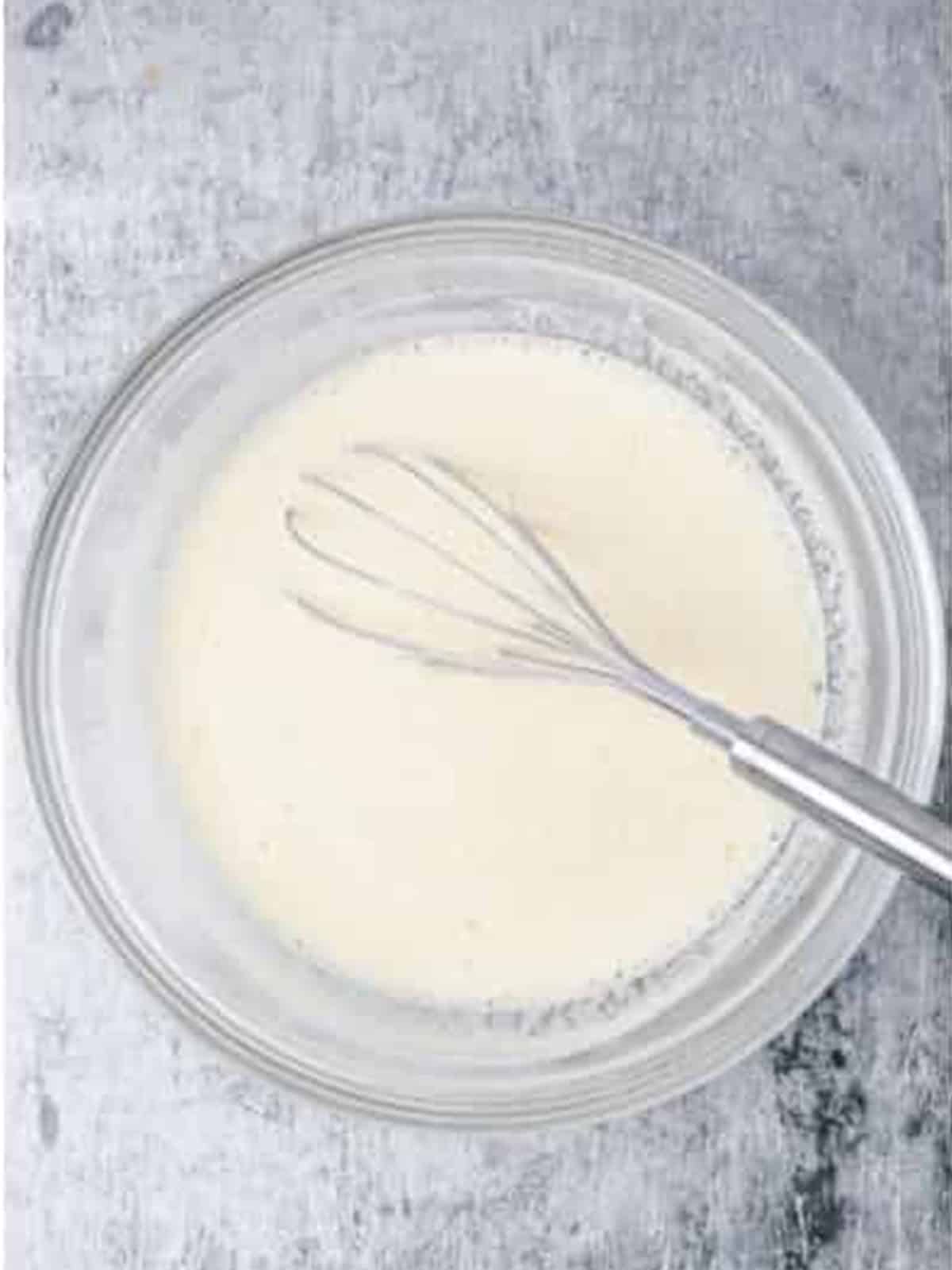 Beer batter whisked together in a glass bowl for salt and pepper shrimp.