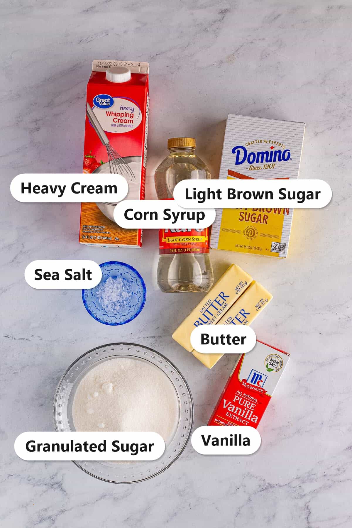 Labeled ingredients for salted caramels including butter, light brown sugar, granulated sugar, corn syrup, heavy cream, vanilla, and sea salt.