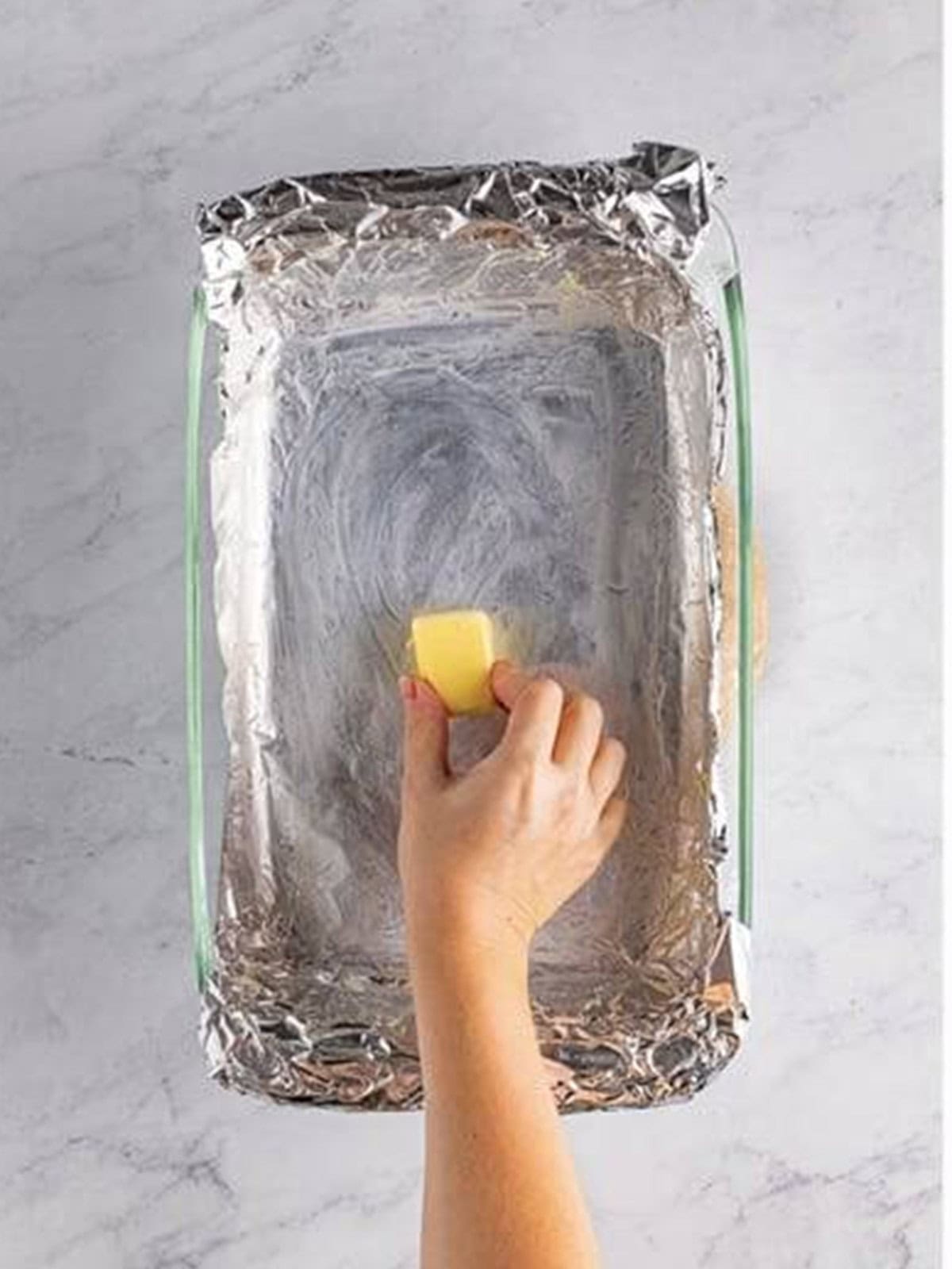 A baking dish lined with foil and greased with butter for salted caramels.