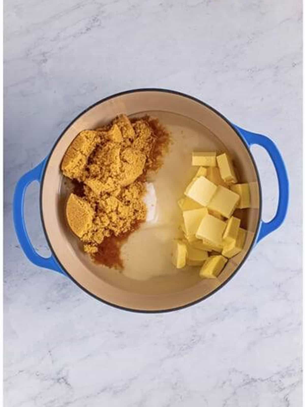 Butter, brown sugar, granulated sugar, and corn syrup combined in a pot for salted caramels.