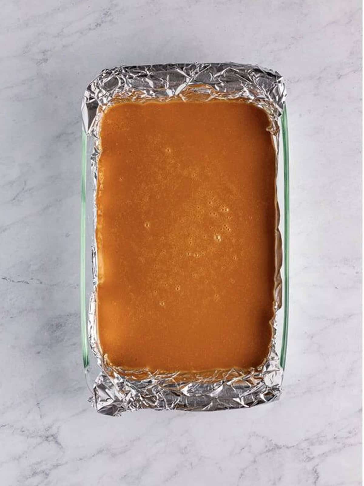 Caramel poured into a foil-lined pan to set for salted caramels.