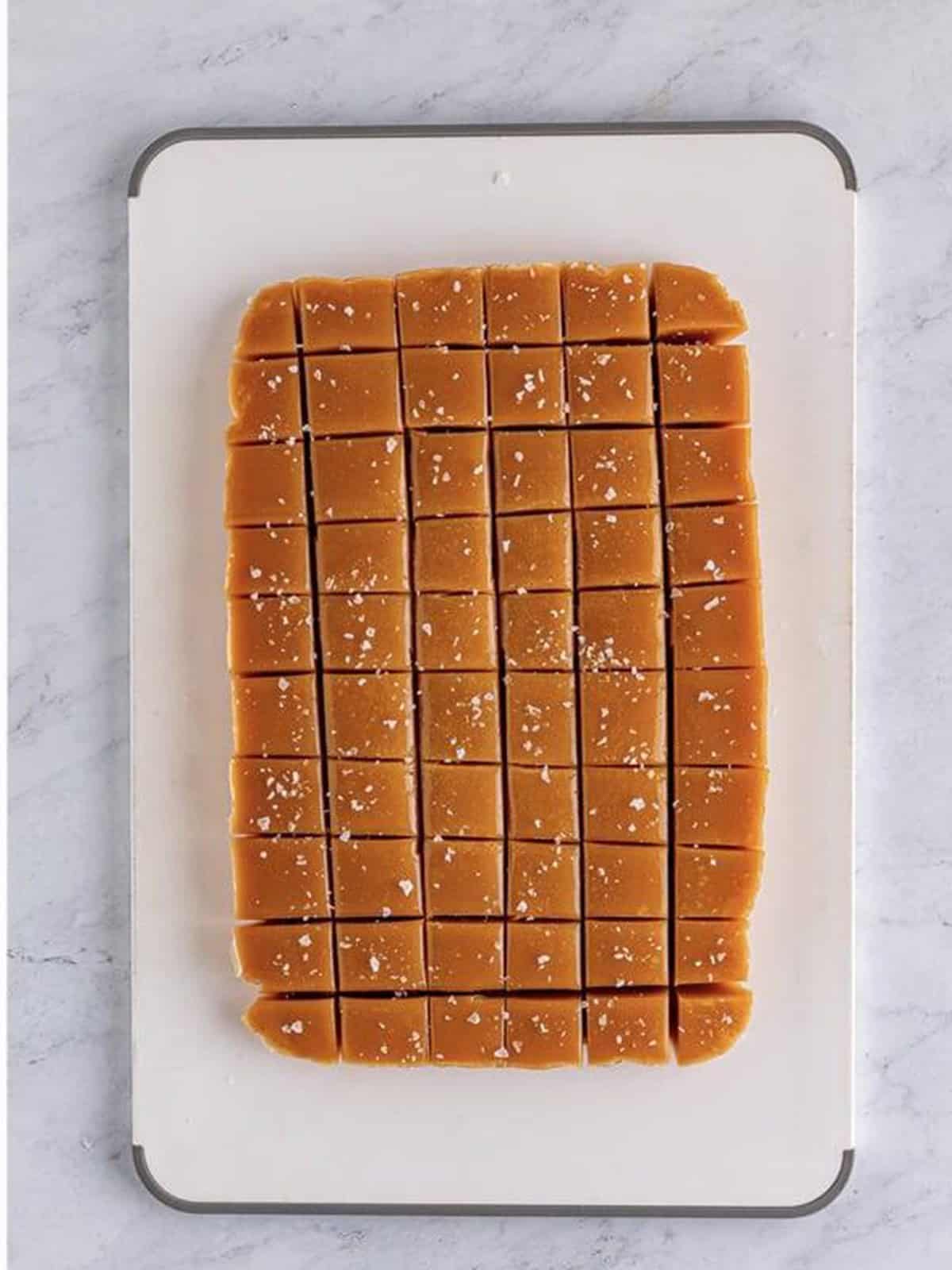 Salted caramel squares sprinkled with flaky sea salt.