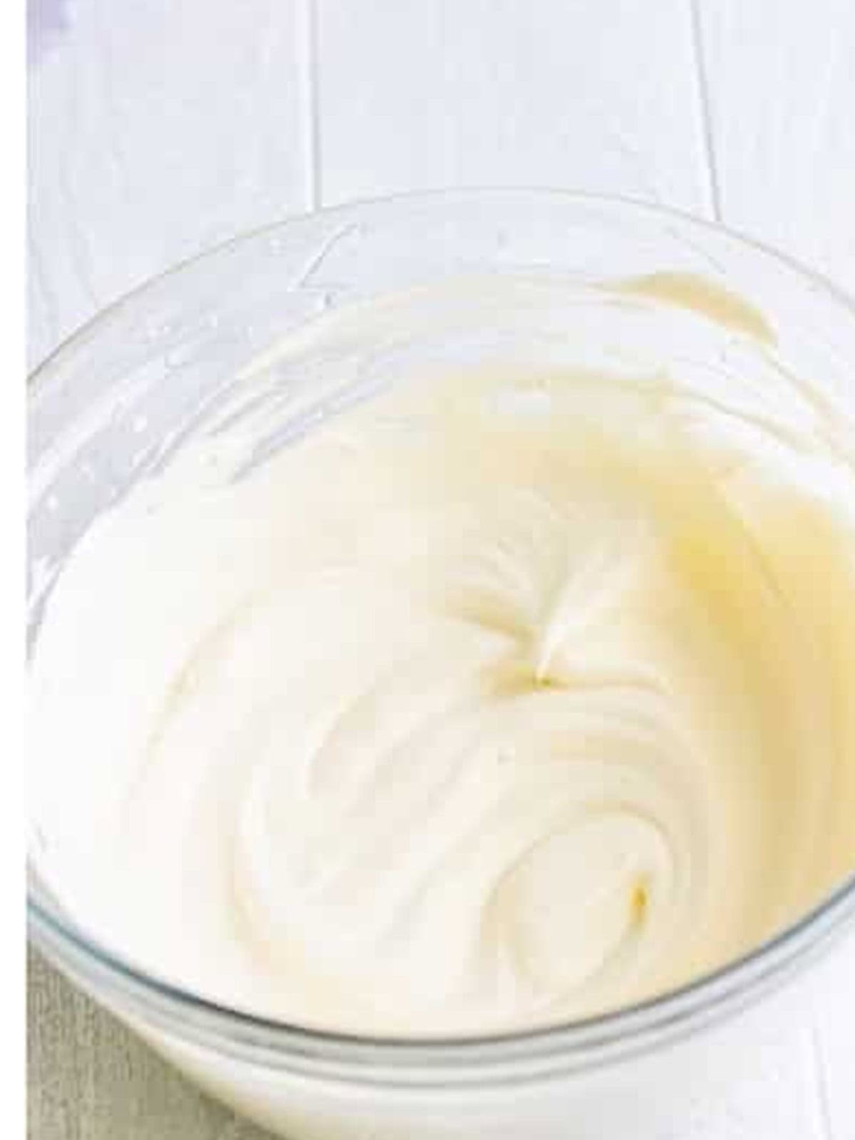 Heavy cream whipped to stiff peaks in a glass bowl.