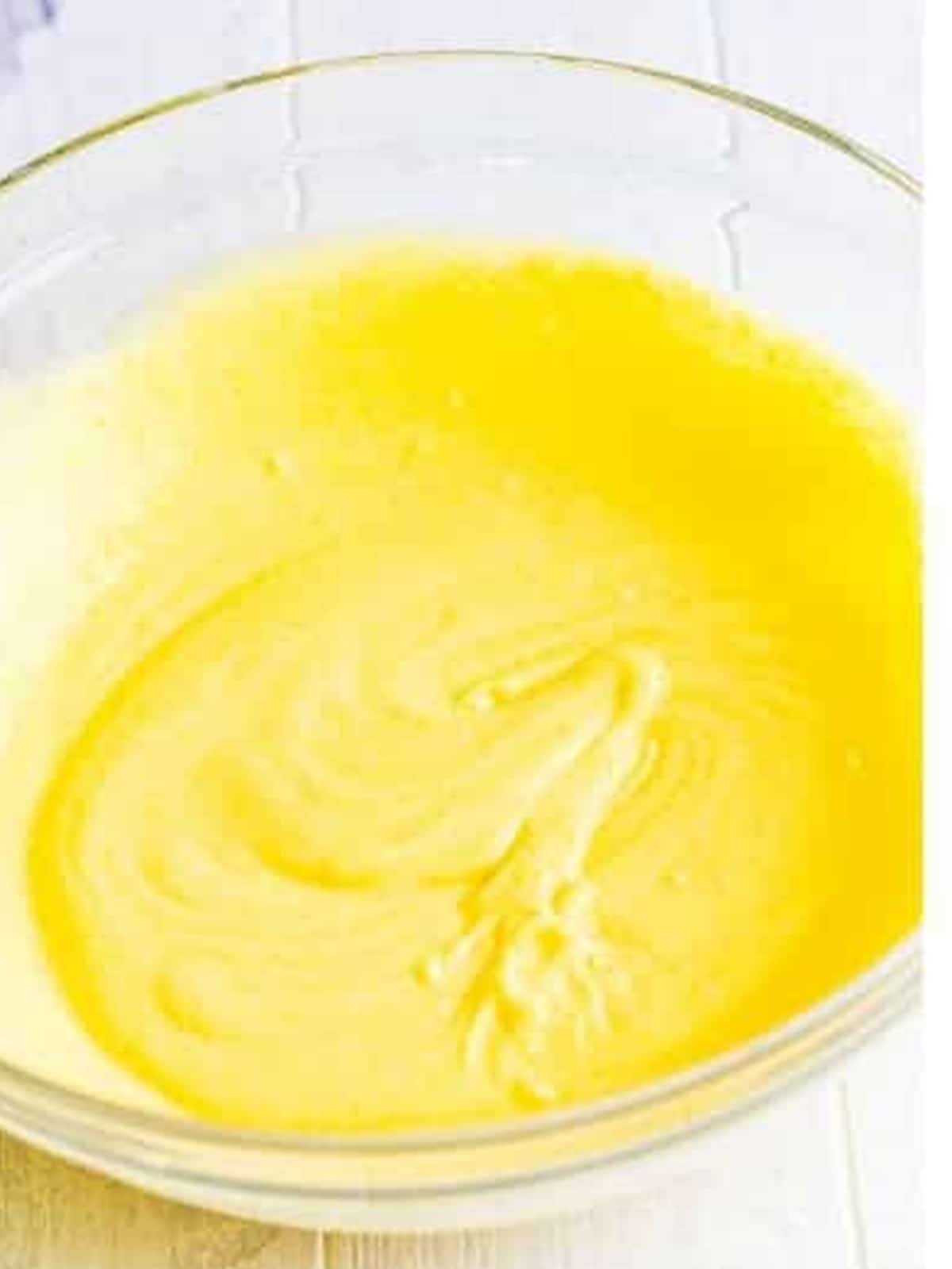 Vanilla pudding whisked with milk in a glass bowl.
