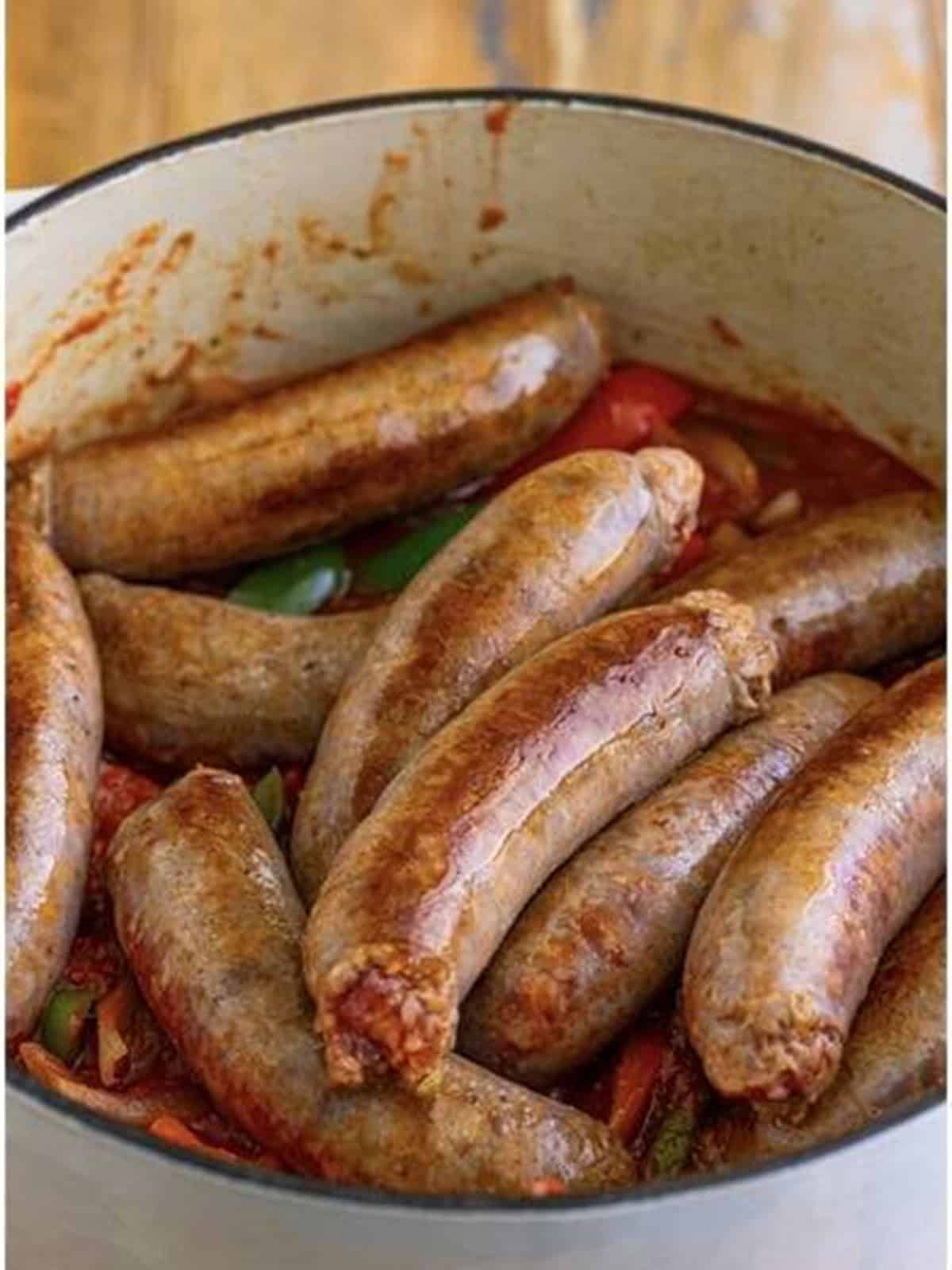 Browned sausages added back into the pot and coated in the marsala tomato sauce.