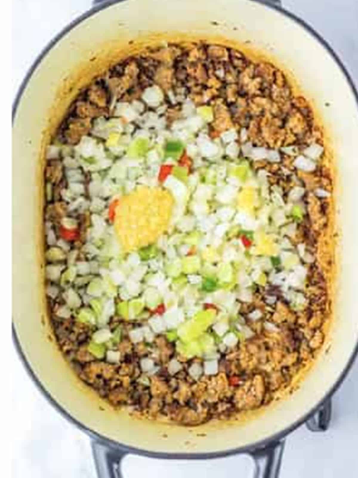 Diced onion, celery, carrot, and red bell pepper added to the cooked sausage.
