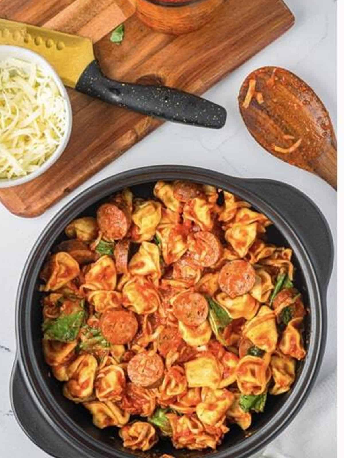 Sausage tortellini mixture poured into the baking dish before going into the oven.
