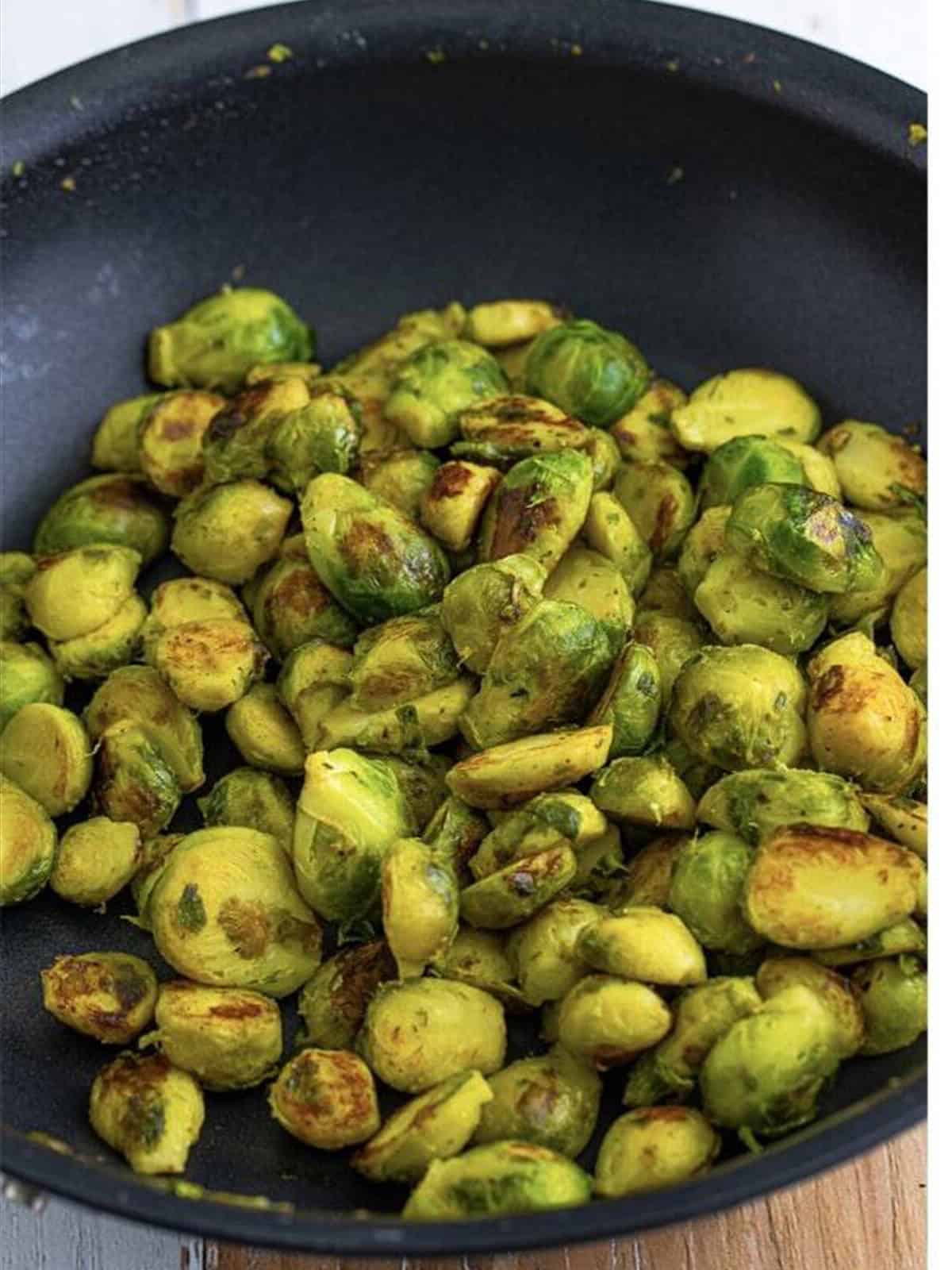 Brussel sprouts cooking in butter in a skillet until golden.