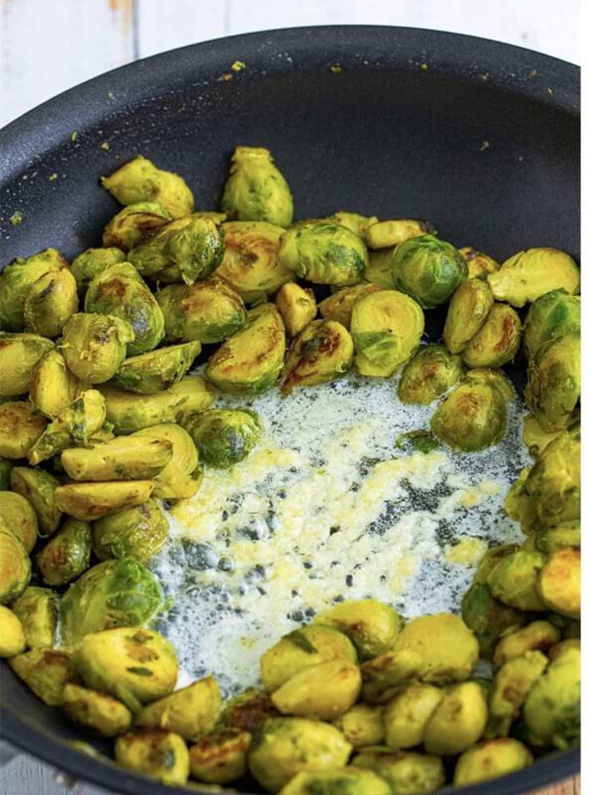 Garlic sauteing in butter in the center of the skillet.