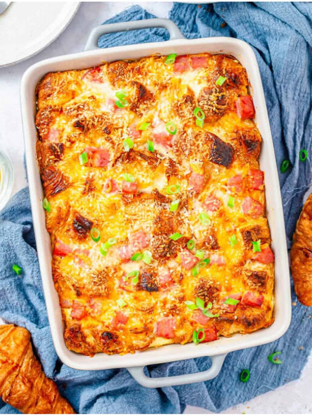 Golden baked ham and cheese savory bread pudding in a baking dish.