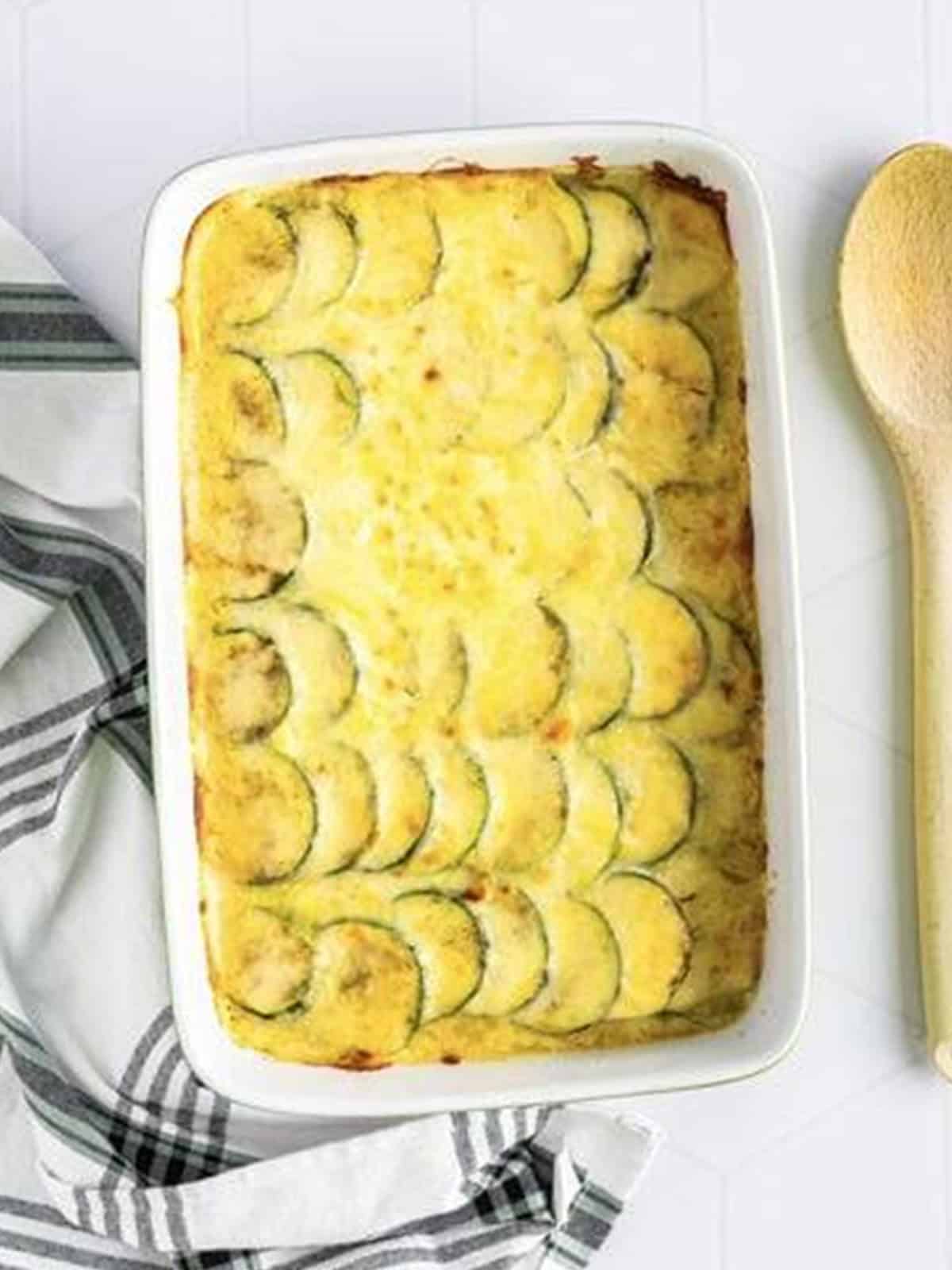 Baked scalloped zucchini with golden, bubbly melted cheese on top.