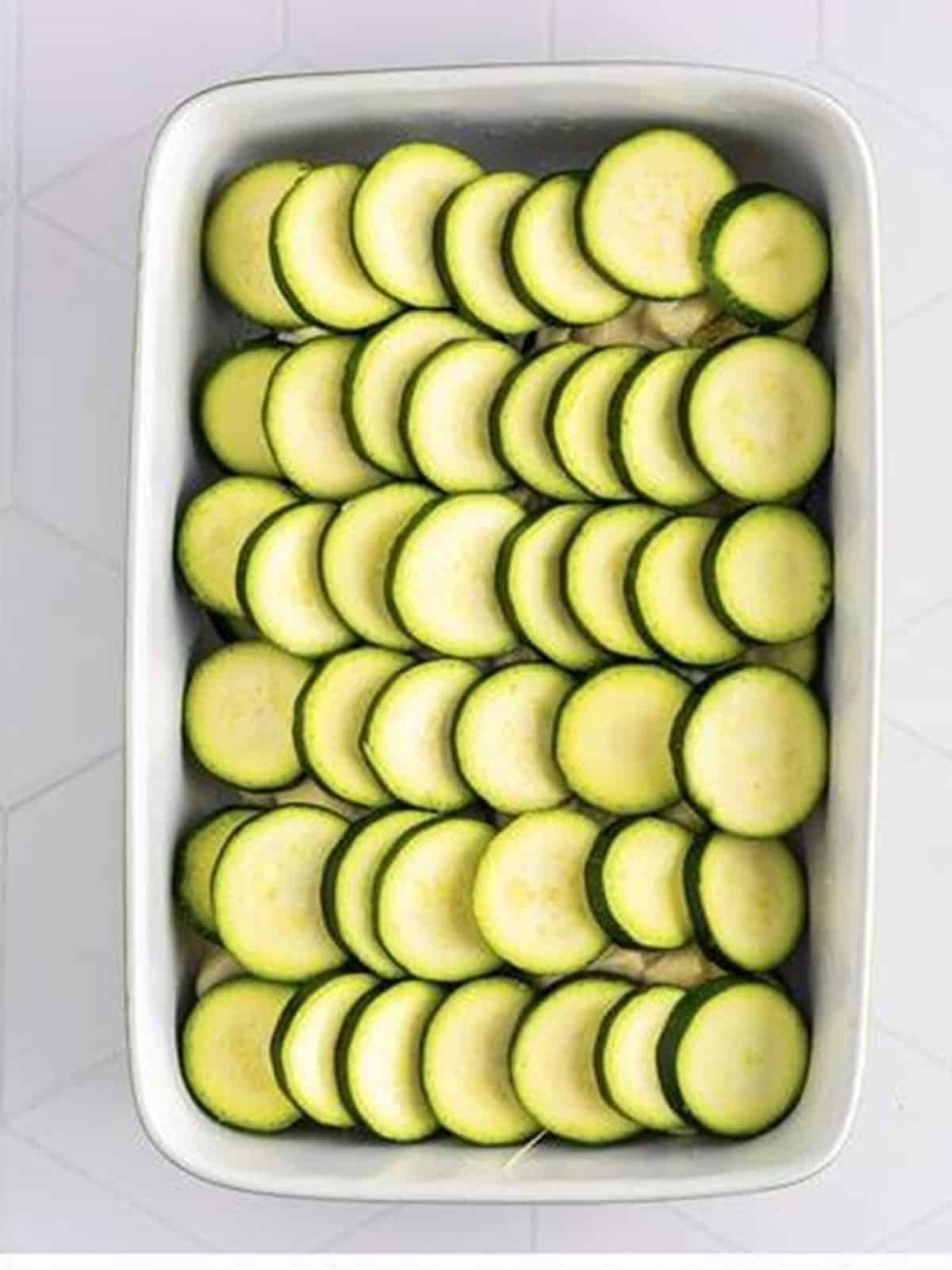 A second layer of zucchini added over the cheese sauce in the baking dish.