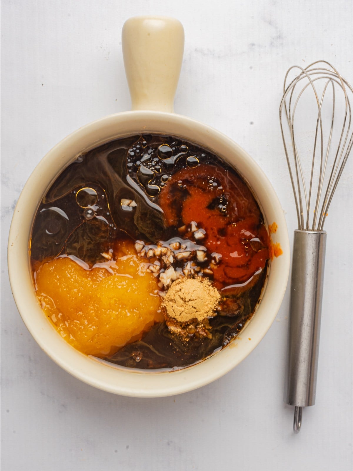Honey, soy sauce, chili sauce, garlic, ginger, and sesame oil combined in a bowl for the sesame chicken sauce.