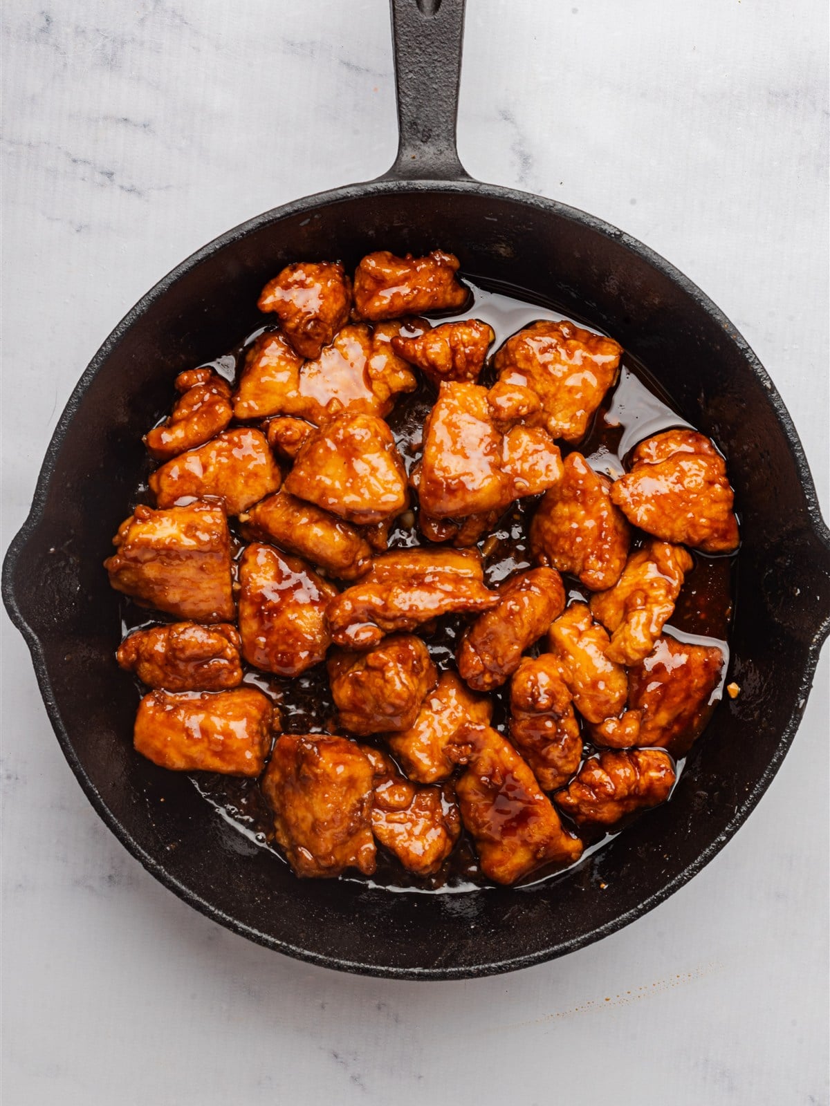 The honey-soy sauce poured over the fried chicken and simmering in the skillet.