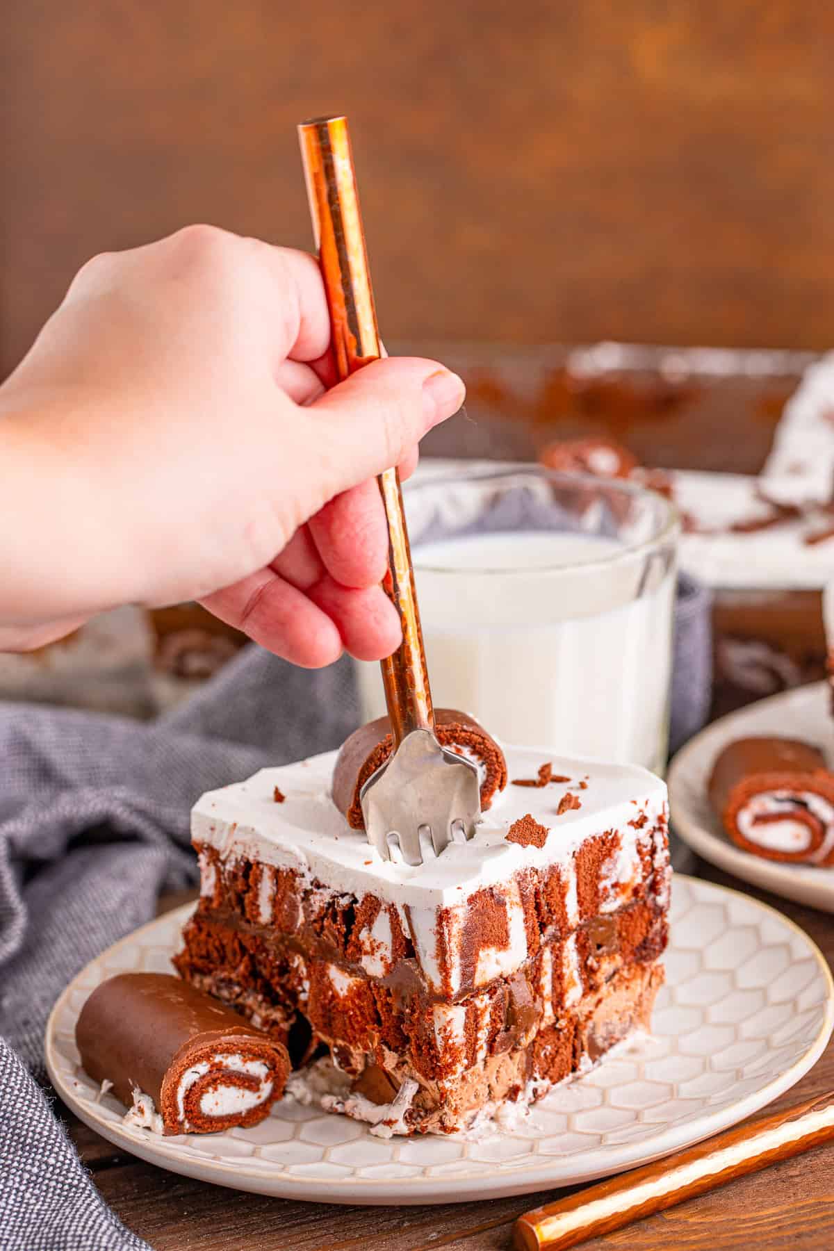 Forkful lifted from a slice of Swiss roll lush cake.