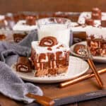 Slice of no bake Swiss roll cake on a plate with a glass of milk.