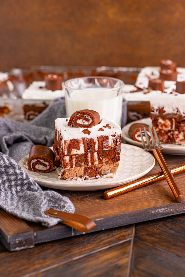 Slice of no bake Swiss roll cake on a plate with a glass of milk.