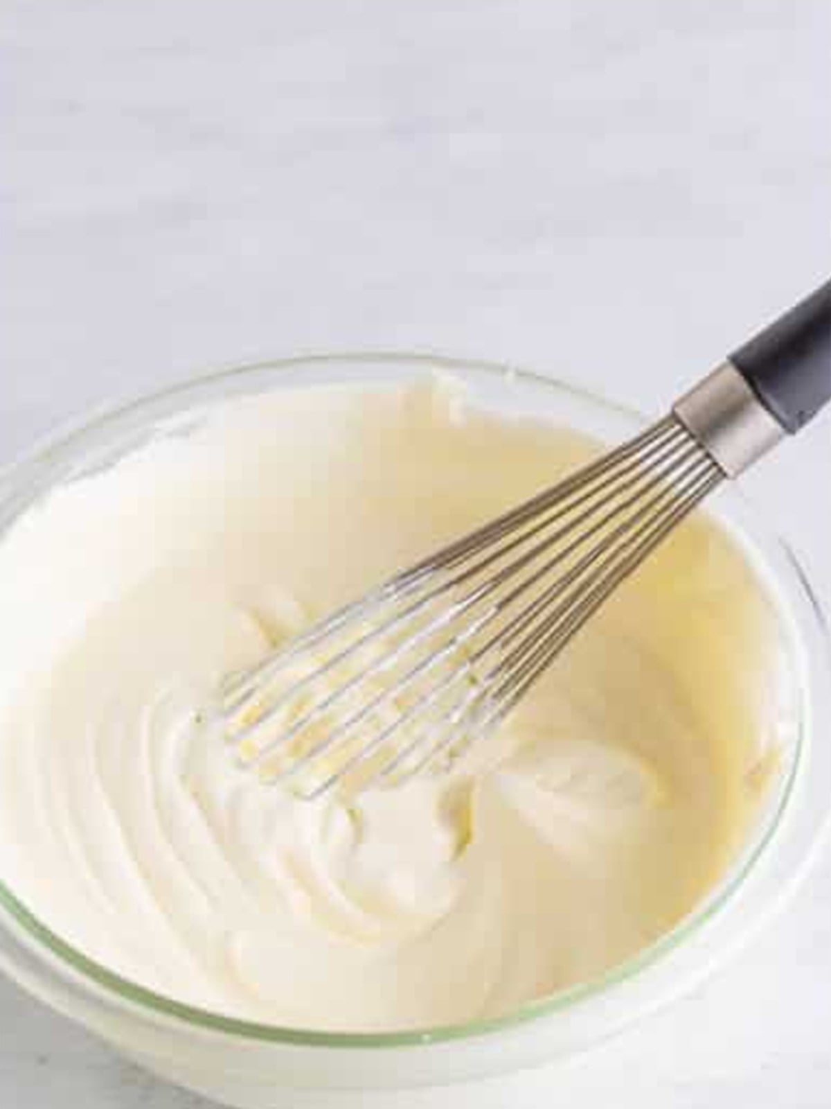 Heavy cream whipped to stiff peaks in a glass bowl for a shamrock shake.