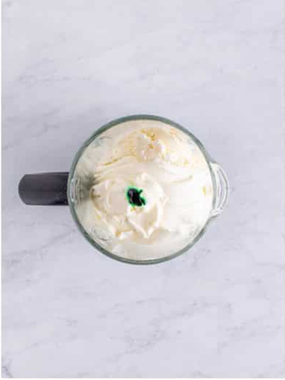 Vanilla ice cream, milk, peppermint, and green food coloring added to a blender for a shamrock shake.