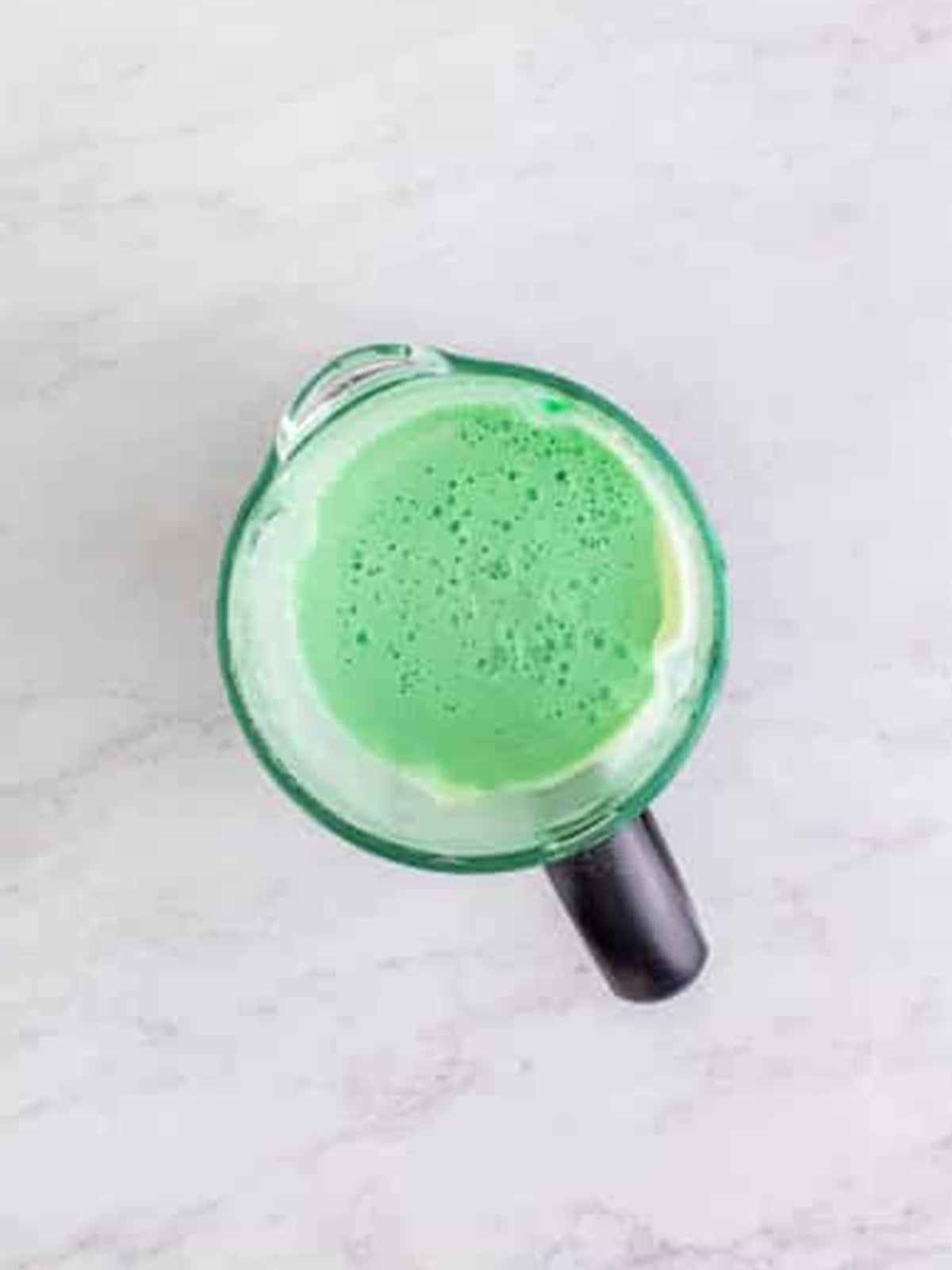 A blended green shamrock shake in the blender jar.