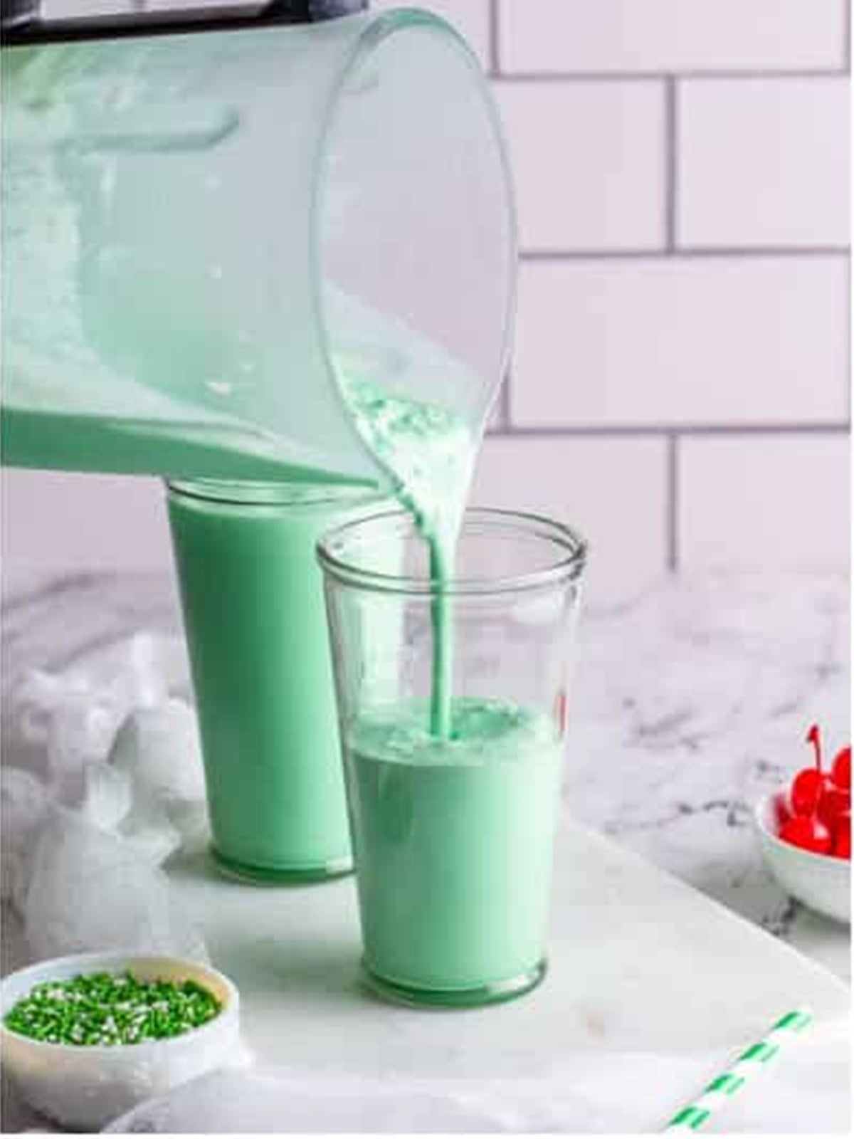 Pouring the green shamrock shake into a glass to serve.