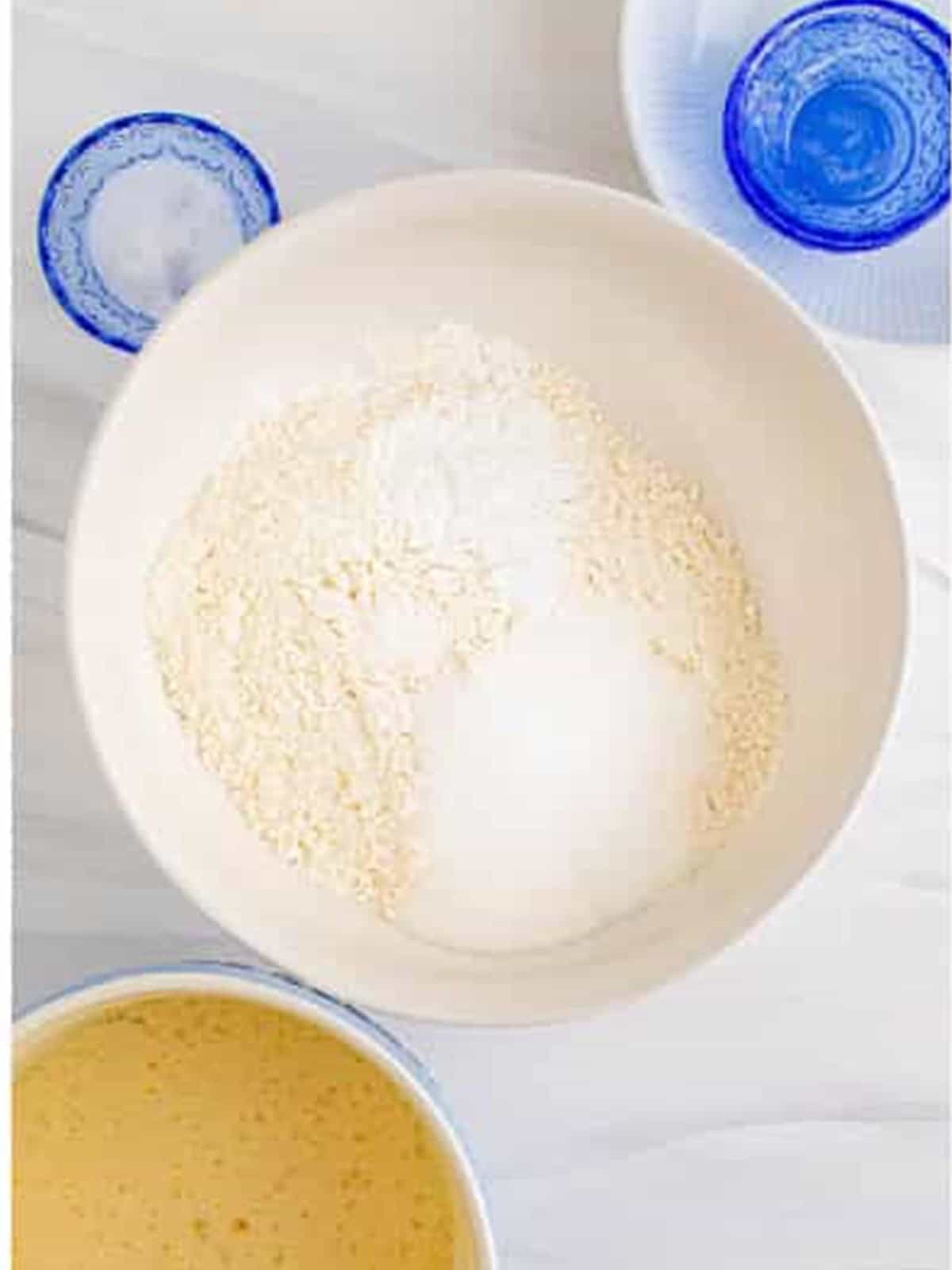 Adding the flour and dry ingredients to the wet batter for sheet pan pancakes.