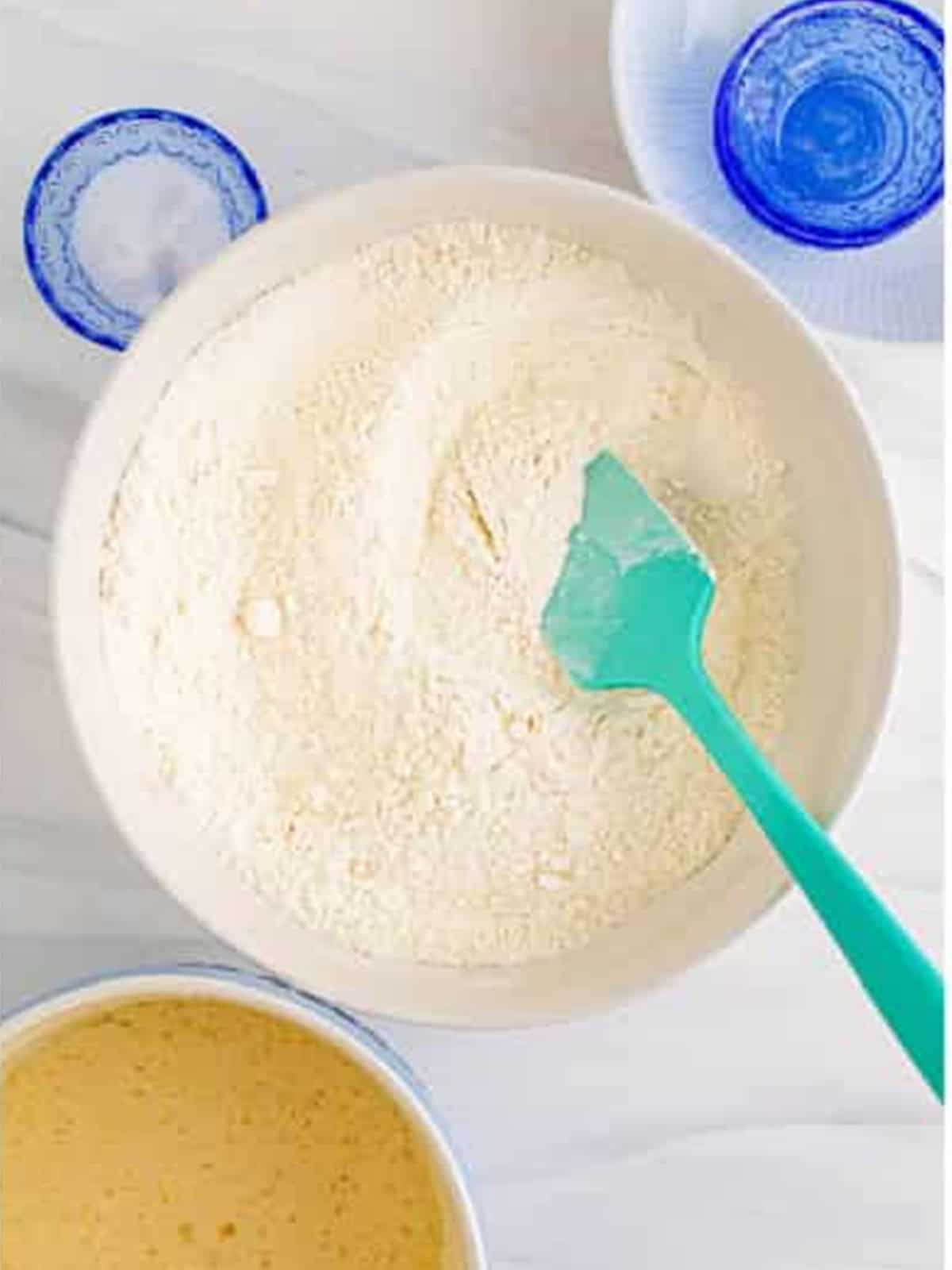 Mixing the sheet pan pancake batter with a spatula.
