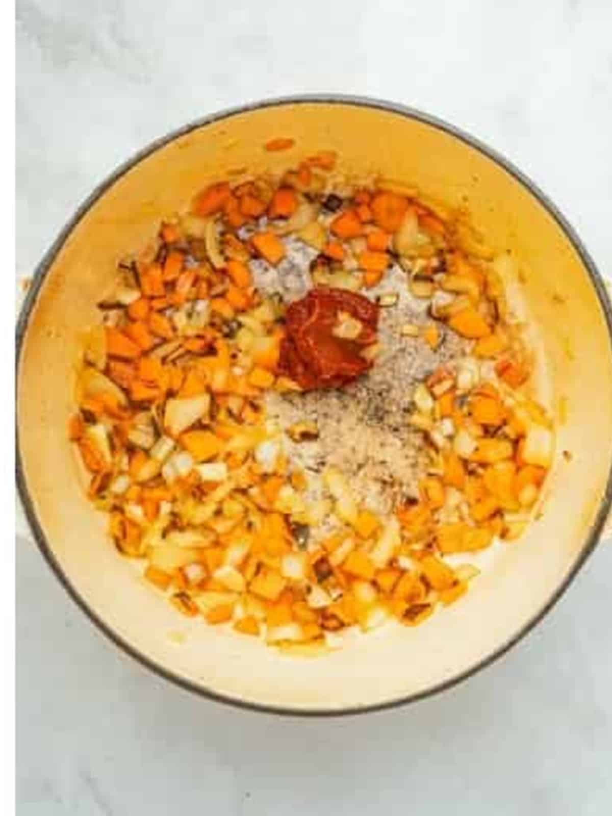 Diced onion, carrot, and garlic sauteed with tomato paste to build the flavor base.