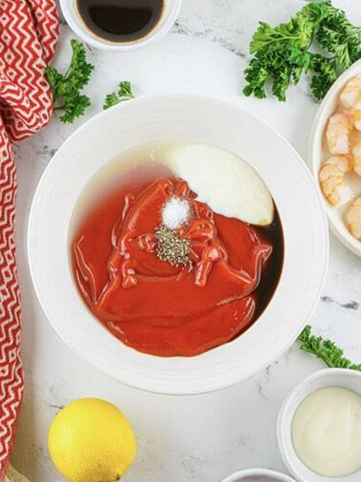 Ketchup, horseradish, lemon juice, and seasonings combined in a bowl for shrimp cocktail sauce.