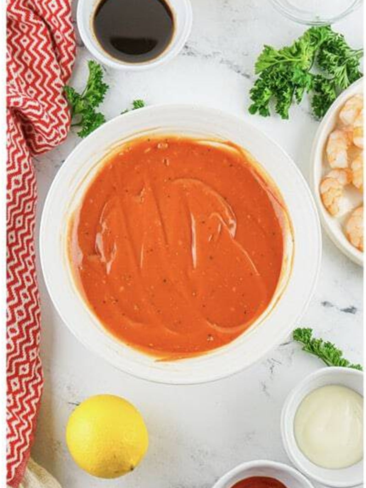 Smooth homemade cocktail sauce whisked together in a white bowl for shrimp cocktail.