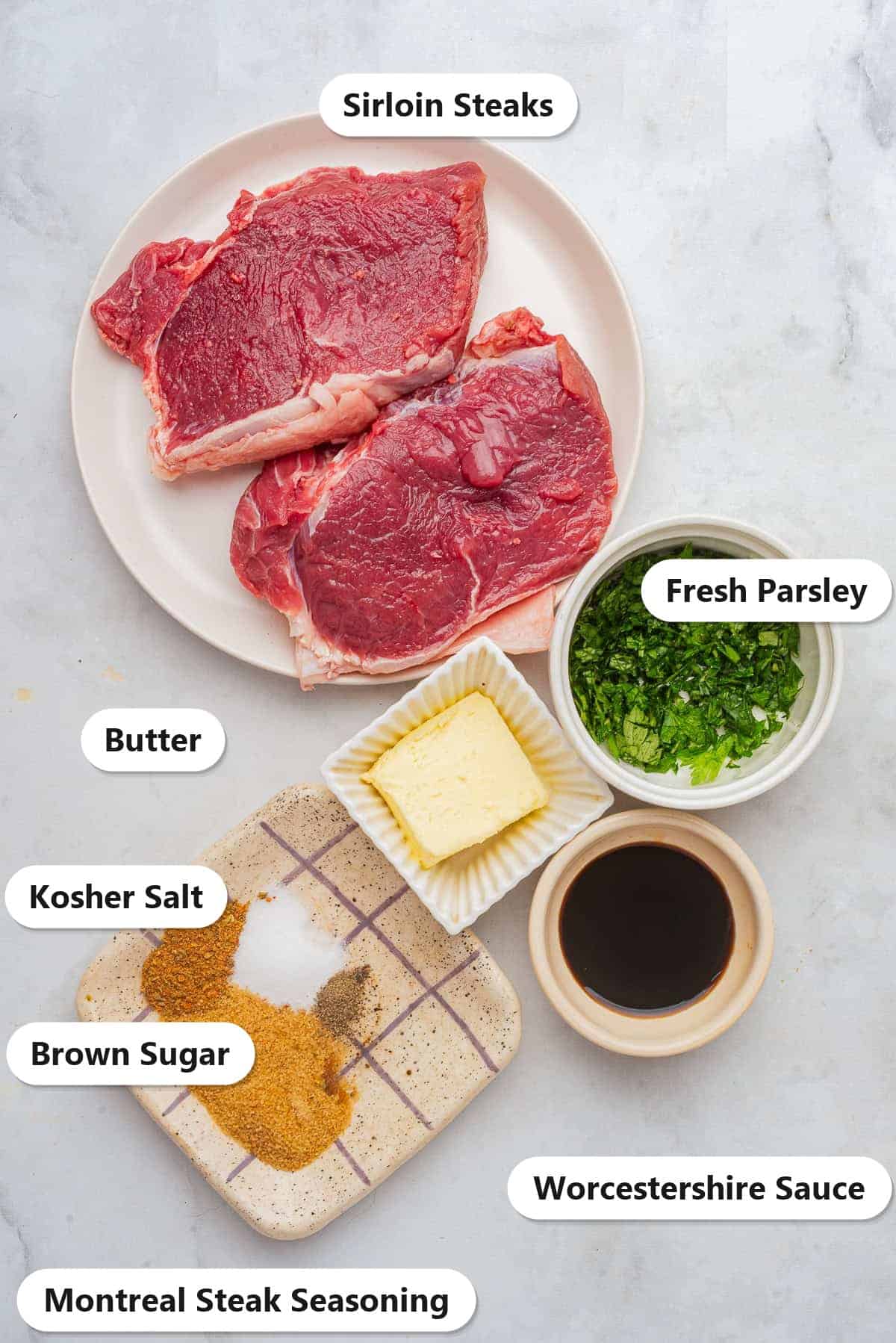 Labeled ingredients for sirloin steak marinade including sirloin steaks, Worcestershire sauce, brown sugar, Montreal steak seasoning, kosher salt, butter, and fresh parsley.