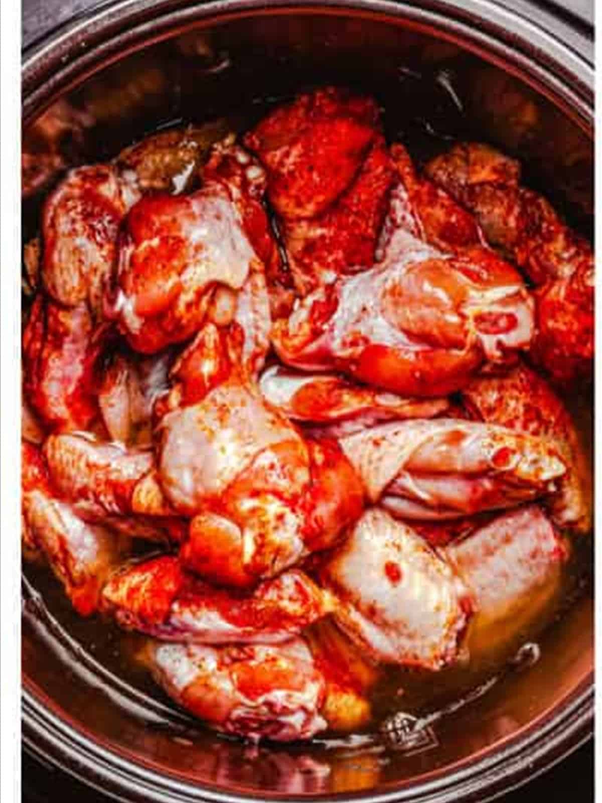Seasoned raw chicken wings layered in the slow cooker for BBQ chicken wings.