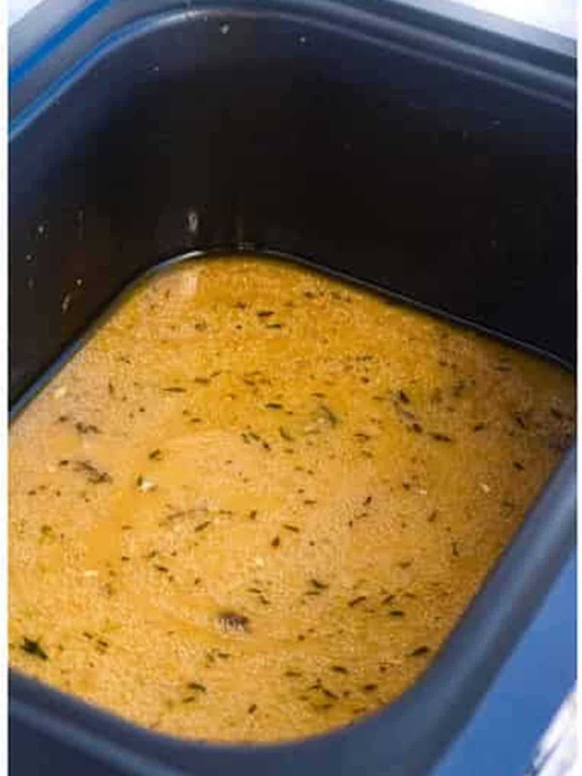 Marsala wine, chicken stock, garlic, and thyme whisked together in the slow cooker.