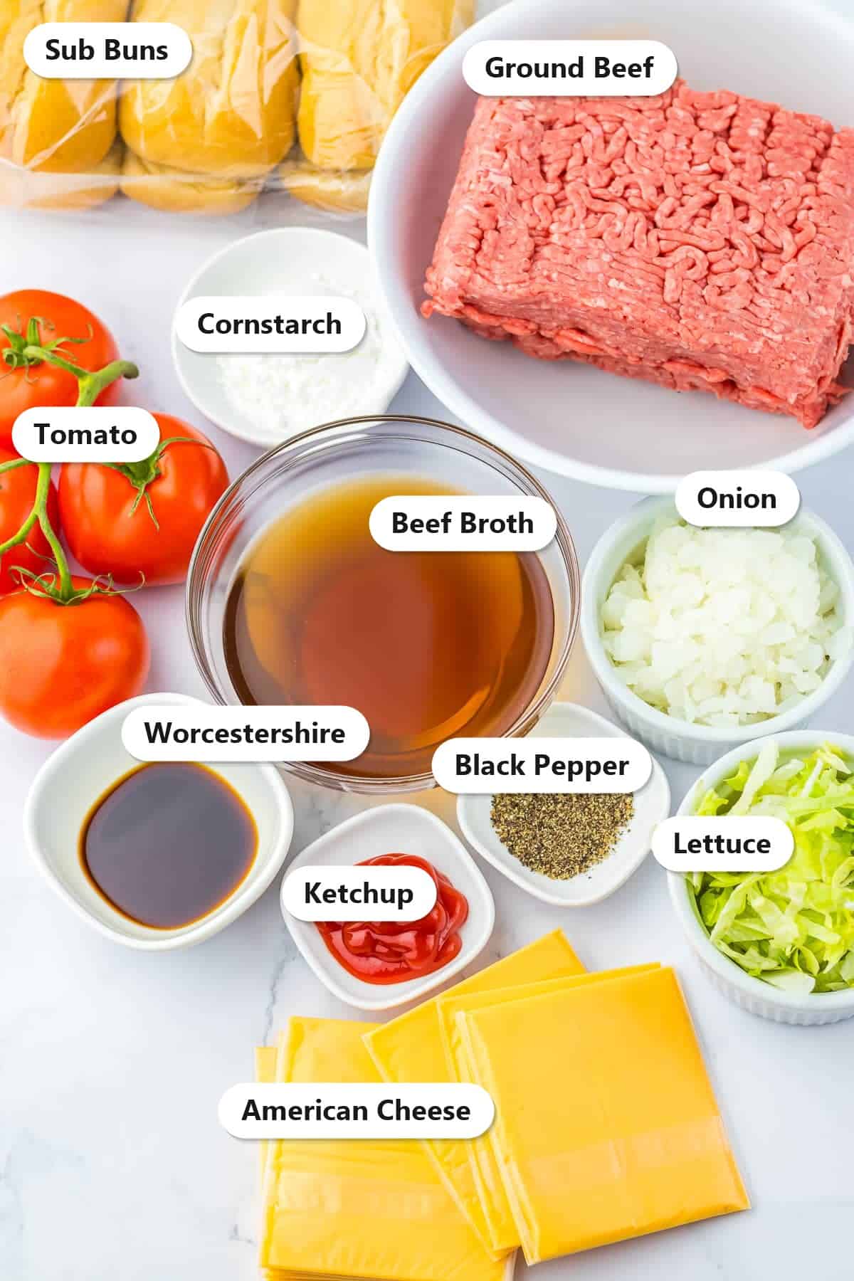 Labeled ingredients to make slow cooker chopped cheese sandwiches including ground beef, onion, beef broth, American cheese, and sub buns.