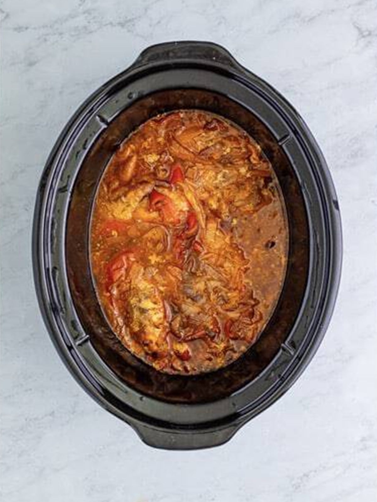 Tender cooked chicken in the slow cooker ready to shred.