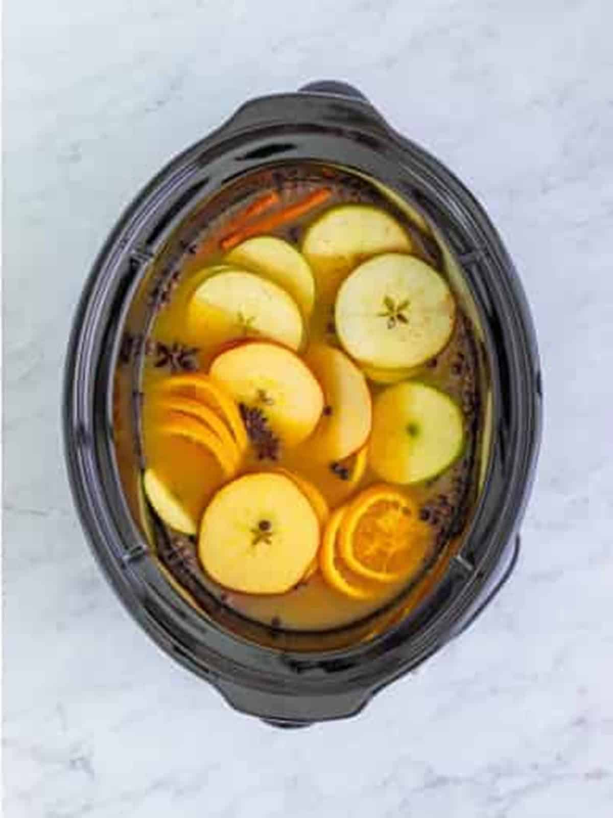 Apple and orange slices added to the slow cooker wassail.