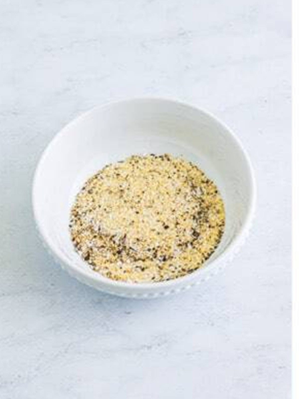 Salt, pepper, garlic powder, and onion powder stirred together in a bowl for smash burgers.